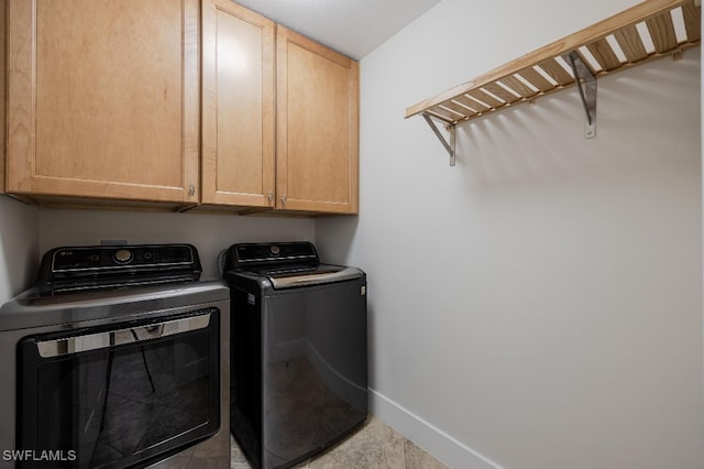 laundry room with washer and clothes dryer and cabinets