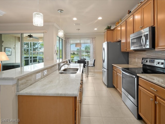 kitchen with stainless steel appliances, a sink, a center island with sink, and ornamental molding