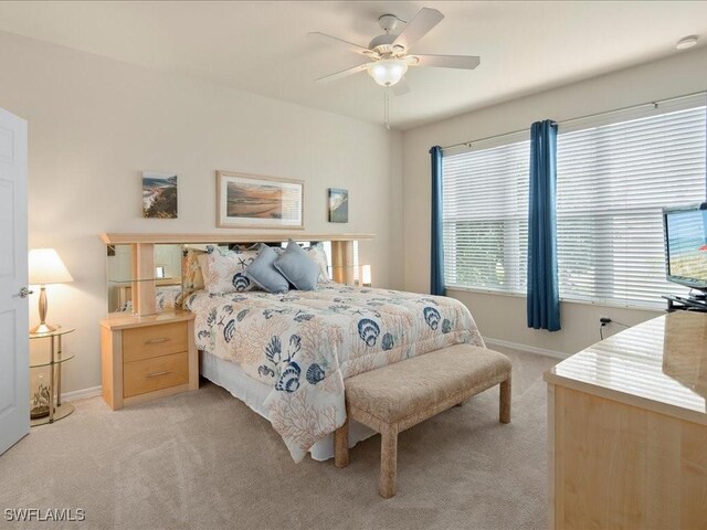 bedroom featuring baseboards, a ceiling fan, and light colored carpet