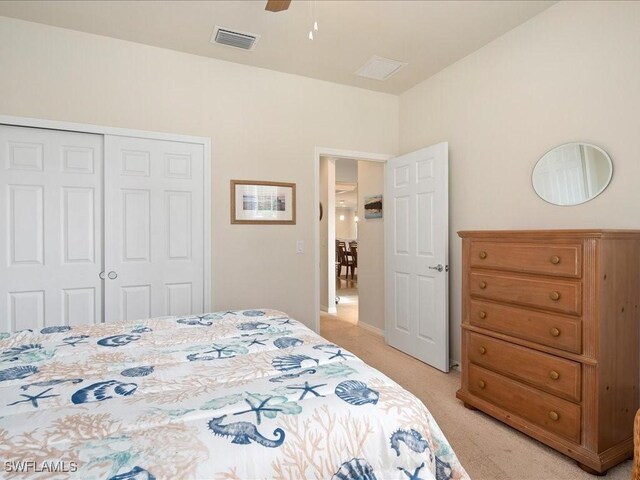 bedroom with a closet, light carpet, ceiling fan, and visible vents