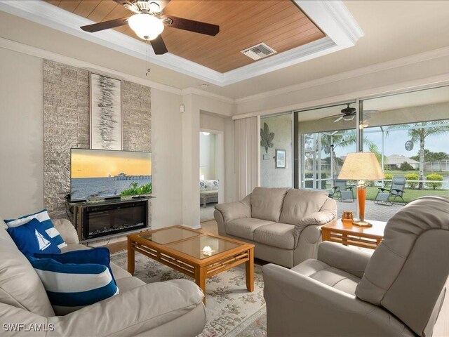 living area featuring ornamental molding, a tray ceiling, wooden ceiling, and visible vents