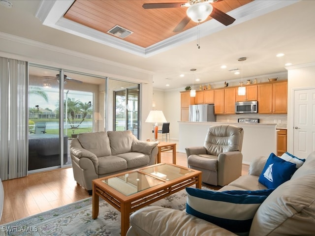 living room with a tray ceiling, visible vents, light wood-style flooring, ornamental molding, and wood ceiling