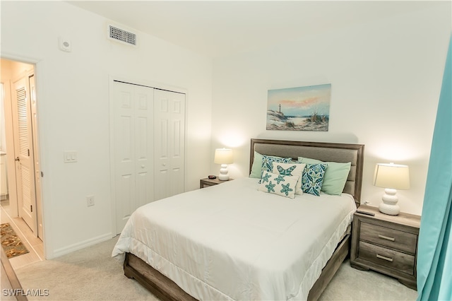 bedroom featuring light colored carpet and a closet