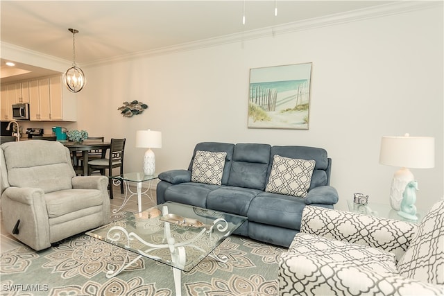 living room featuring a notable chandelier, sink, and ornamental molding