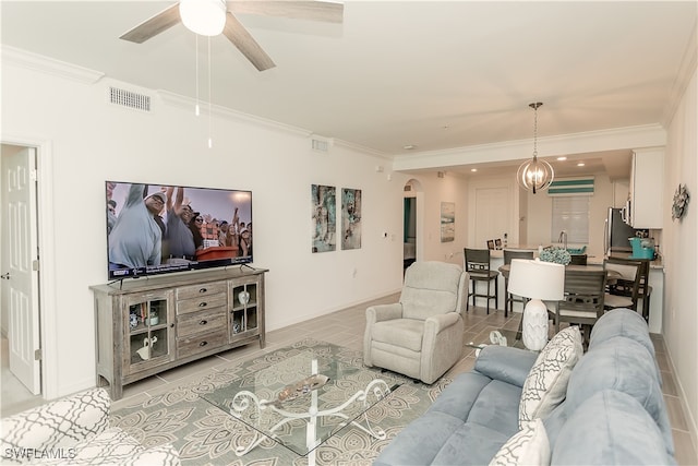 tiled living room featuring ceiling fan with notable chandelier, crown molding, and sink