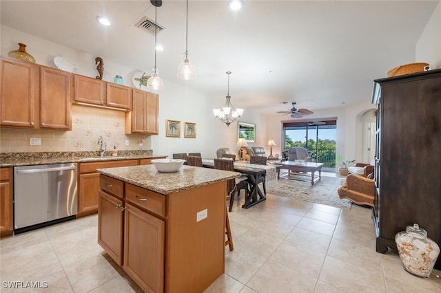 kitchen featuring sink, ceiling fan with notable chandelier, hanging light fixtures, a kitchen island, and stainless steel dishwasher