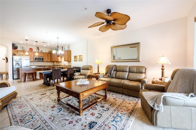 tiled living room with ceiling fan with notable chandelier and sink