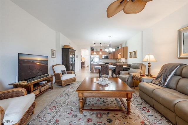 tiled living room with ceiling fan with notable chandelier and sink