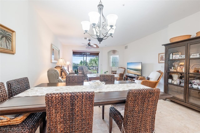 tiled dining room with ceiling fan with notable chandelier