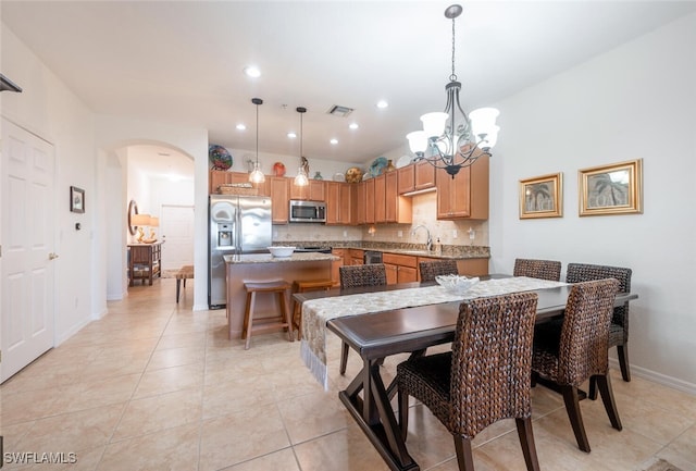 tiled dining area with sink and a chandelier