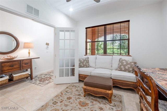 living room featuring ceiling fan, vaulted ceiling, and light tile patterned floors