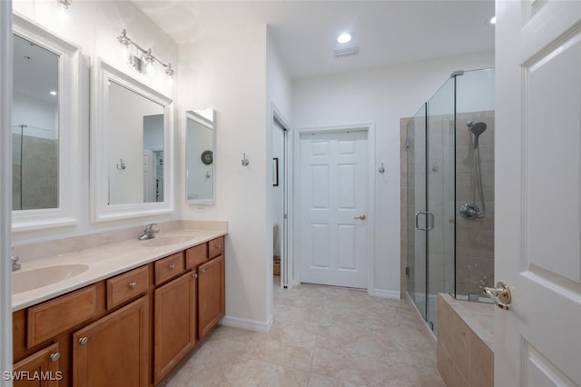 bathroom featuring tile patterned flooring, vanity, and a shower with shower door