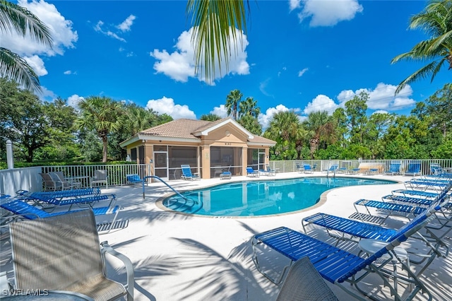 view of swimming pool with a patio and a sunroom