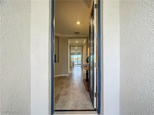 corridor with light hardwood / wood-style floors and ornamental molding