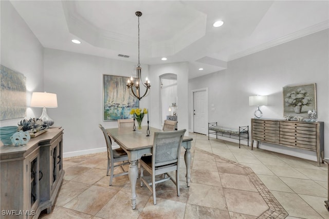 dining area featuring ornamental molding, a tray ceiling, and a chandelier