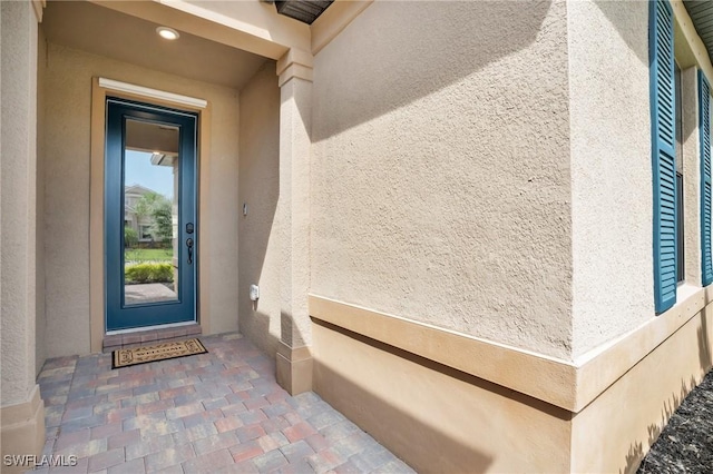 entrance to property featuring stucco siding