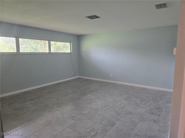 spare room with a textured ceiling