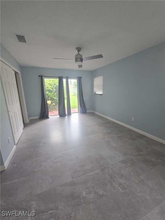 spare room featuring ceiling fan and a textured ceiling