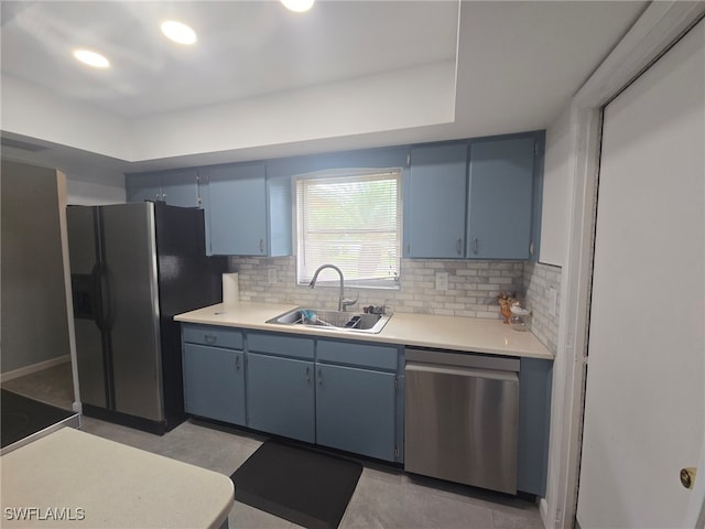 kitchen featuring blue cabinetry, appliances with stainless steel finishes, backsplash, and sink