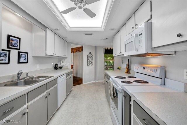 kitchen with ceiling fan, a skylight, sink, white appliances, and white cabinetry