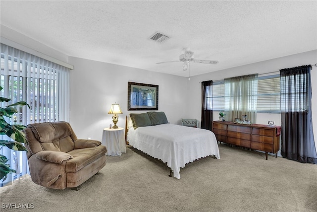 carpeted bedroom with a textured ceiling and ceiling fan