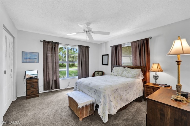 bedroom with dark carpet, a closet, ceiling fan, and a textured ceiling