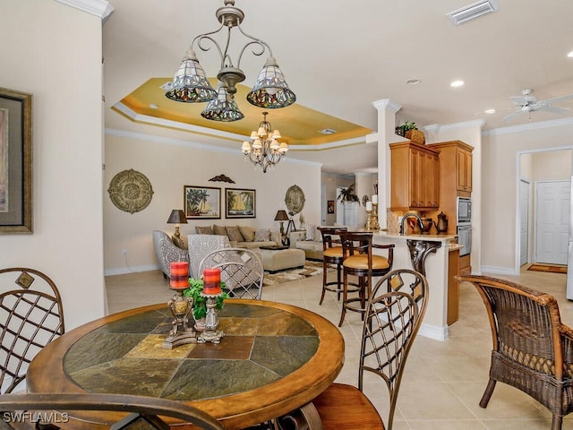 dining room featuring ceiling fan with notable chandelier, ornamental molding, light tile patterned floors, and a raised ceiling