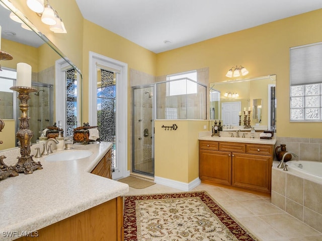 bathroom featuring independent shower and bath, vanity, tile patterned floors, and a wealth of natural light