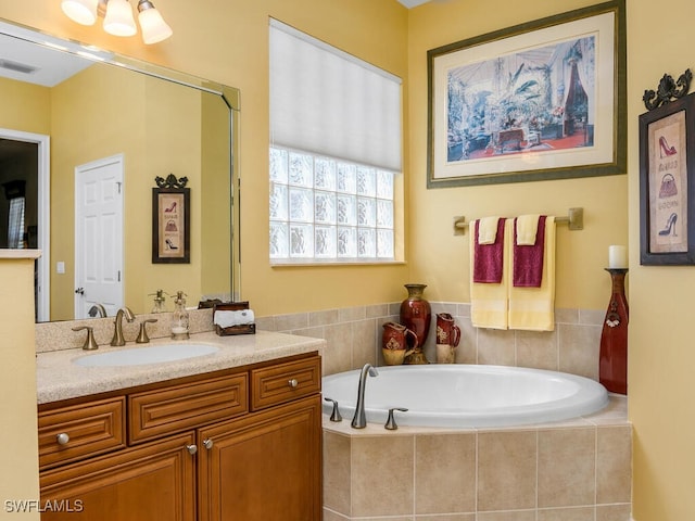 bathroom featuring vanity and tiled bath