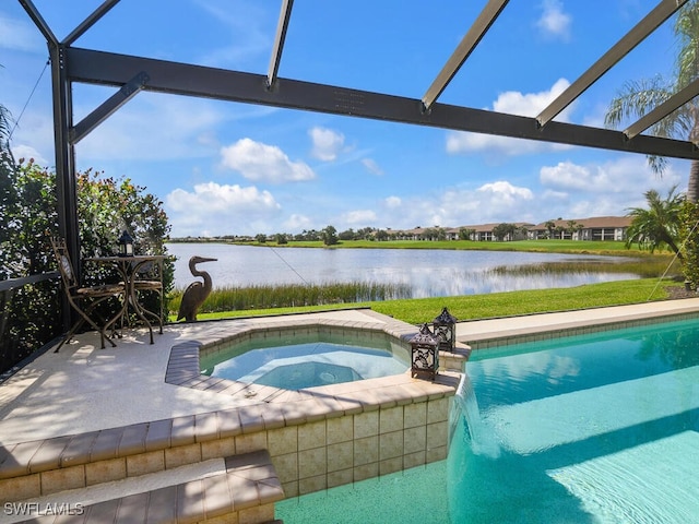 view of swimming pool featuring an in ground hot tub, a water view, and a patio area