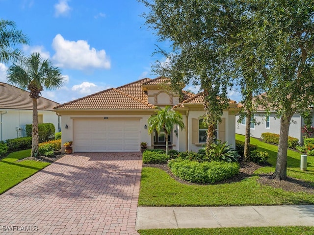 mediterranean / spanish-style house with a garage and a front lawn