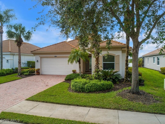 mediterranean / spanish-style house featuring a front yard and a garage