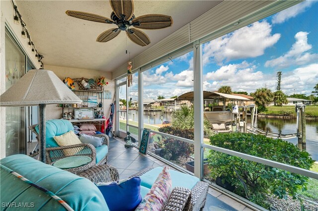 sunroom featuring a water view and ceiling fan