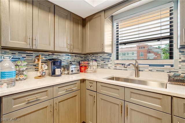 kitchen with sink, backsplash, and light brown cabinets