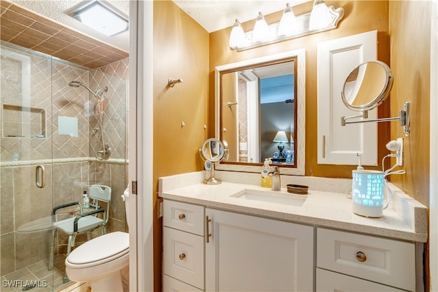 bathroom with vanity, toilet, and a shower with shower door