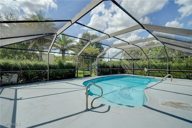 view of swimming pool with glass enclosure and a patio