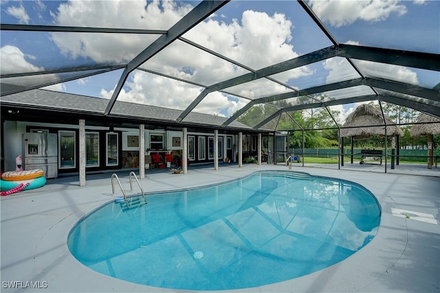 view of swimming pool featuring a patio and a lanai