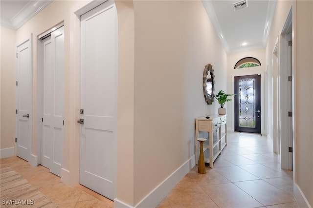 hallway featuring ornamental molding and light tile patterned floors