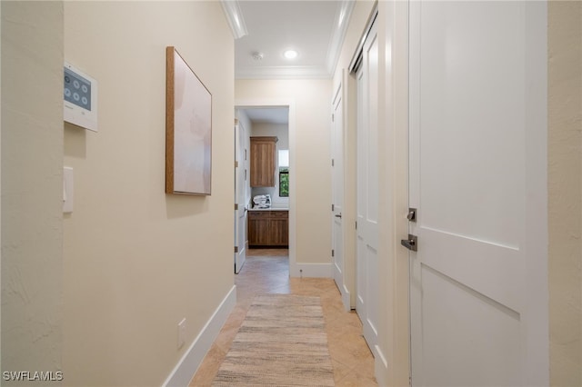 hallway with ornamental molding and light tile patterned flooring