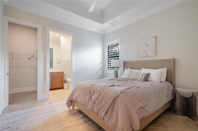 carpeted bedroom with a closet, a walk in closet, crown molding, ensuite bathroom, and ceiling fan