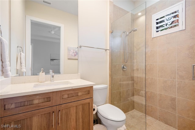 bathroom with vanity, a tile shower, ornamental molding, and toilet