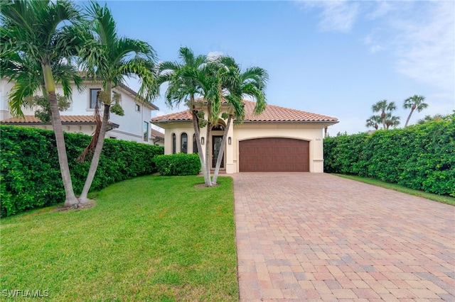 mediterranean / spanish house featuring a front yard and a garage