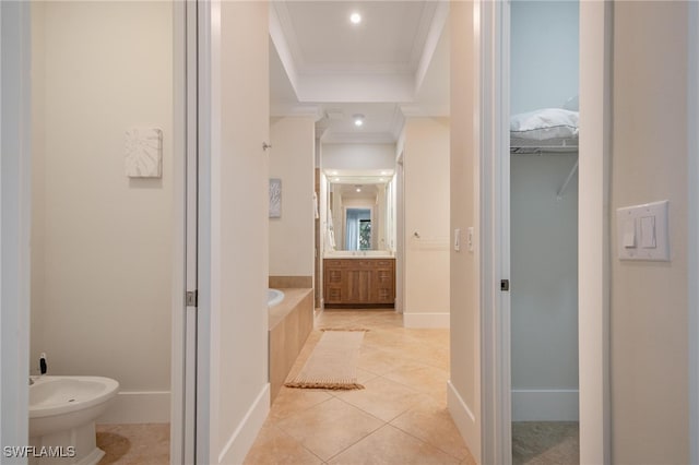 bathroom with tiled bath, vanity, ornamental molding, a bidet, and tile patterned flooring