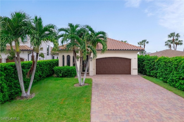 mediterranean / spanish home with a front yard and a garage