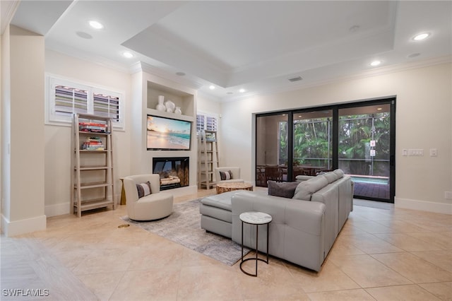 living room with crown molding, a tray ceiling, and light tile patterned floors