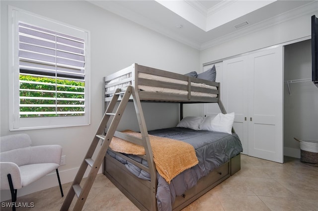 tiled bedroom featuring crown molding and a closet