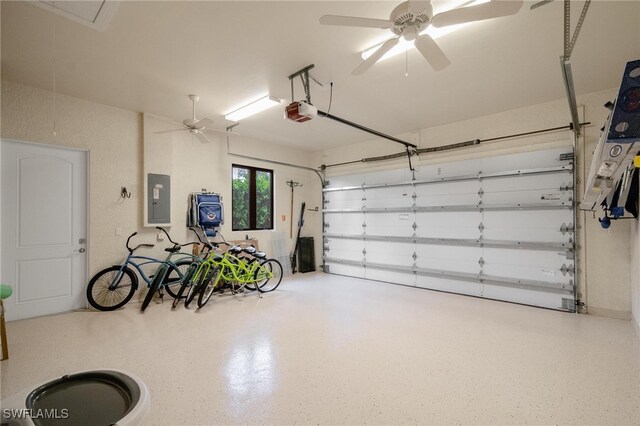 garage featuring a garage door opener, electric panel, and ceiling fan