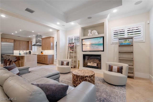 living room featuring sink and crown molding