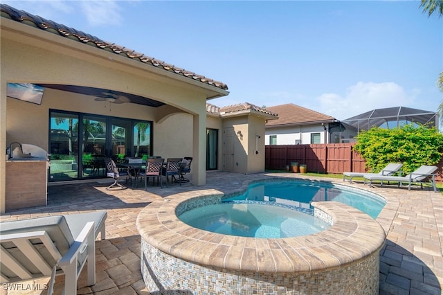 view of pool featuring a patio area, a lanai, an in ground hot tub, and ceiling fan