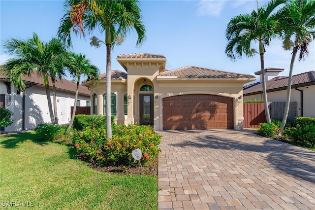 mediterranean / spanish house with a front yard and a garage